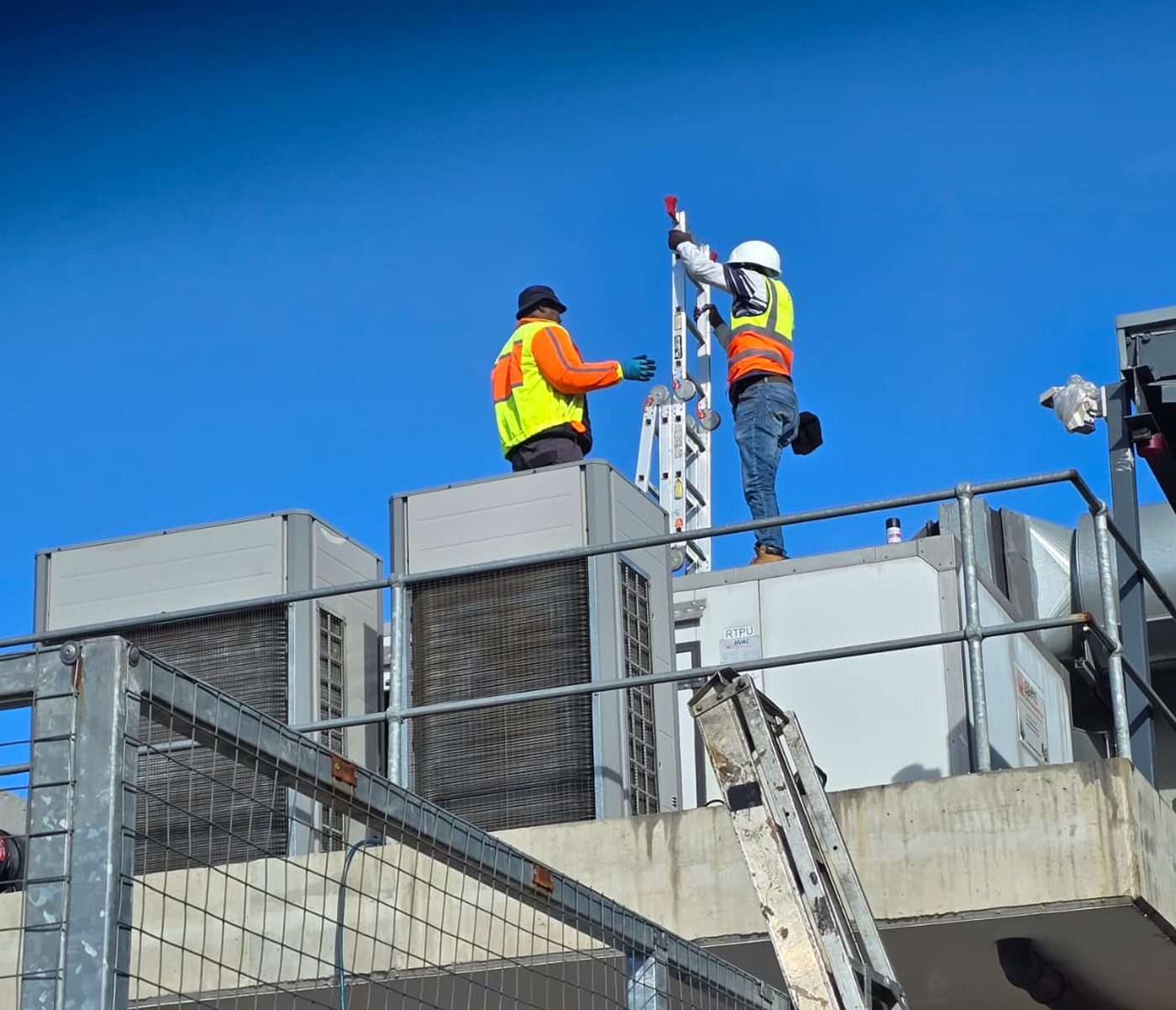 Kgotsobela Consortium technicians working on rooftop HVAC units