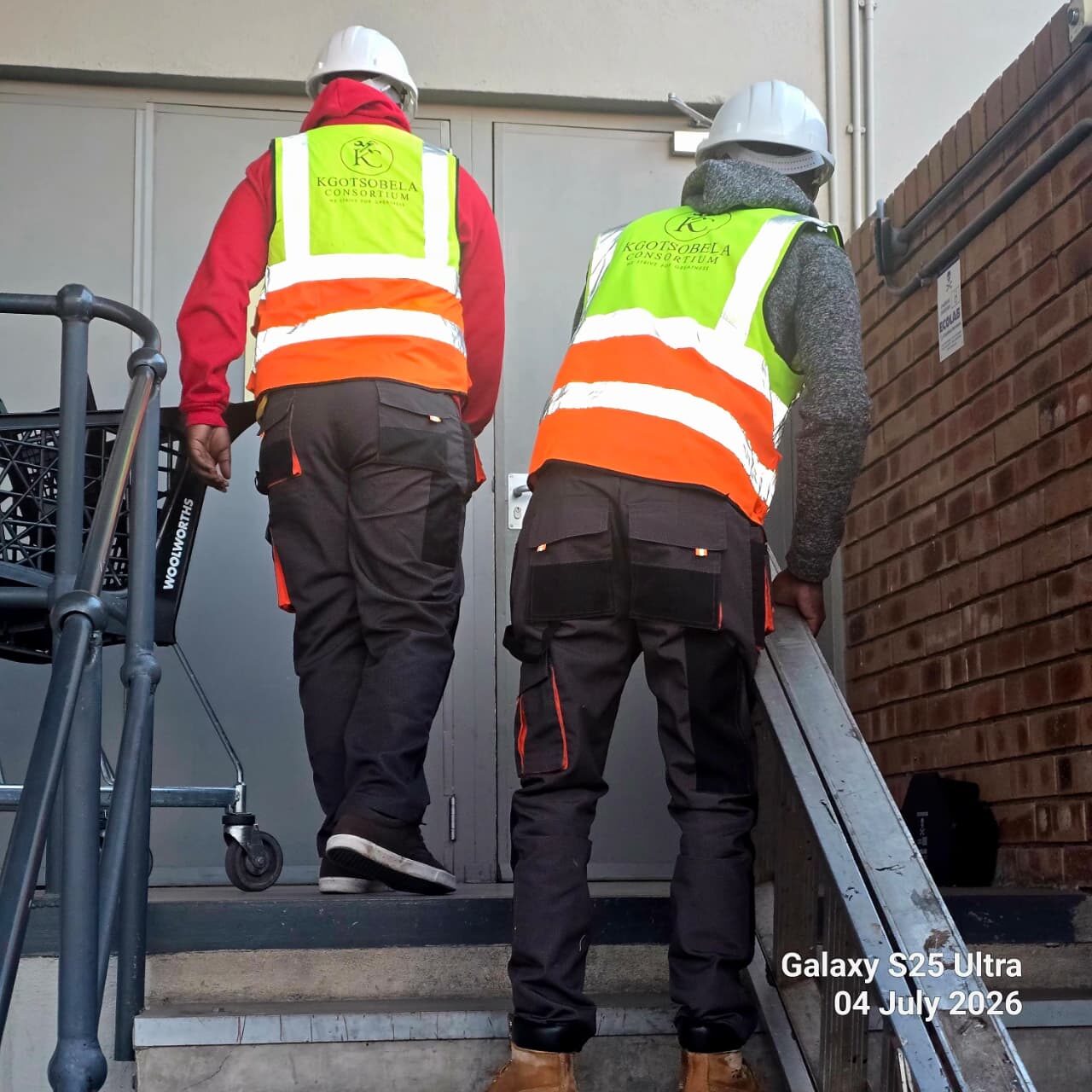 Technicians in full PPE climbing rooftop plant stairs
